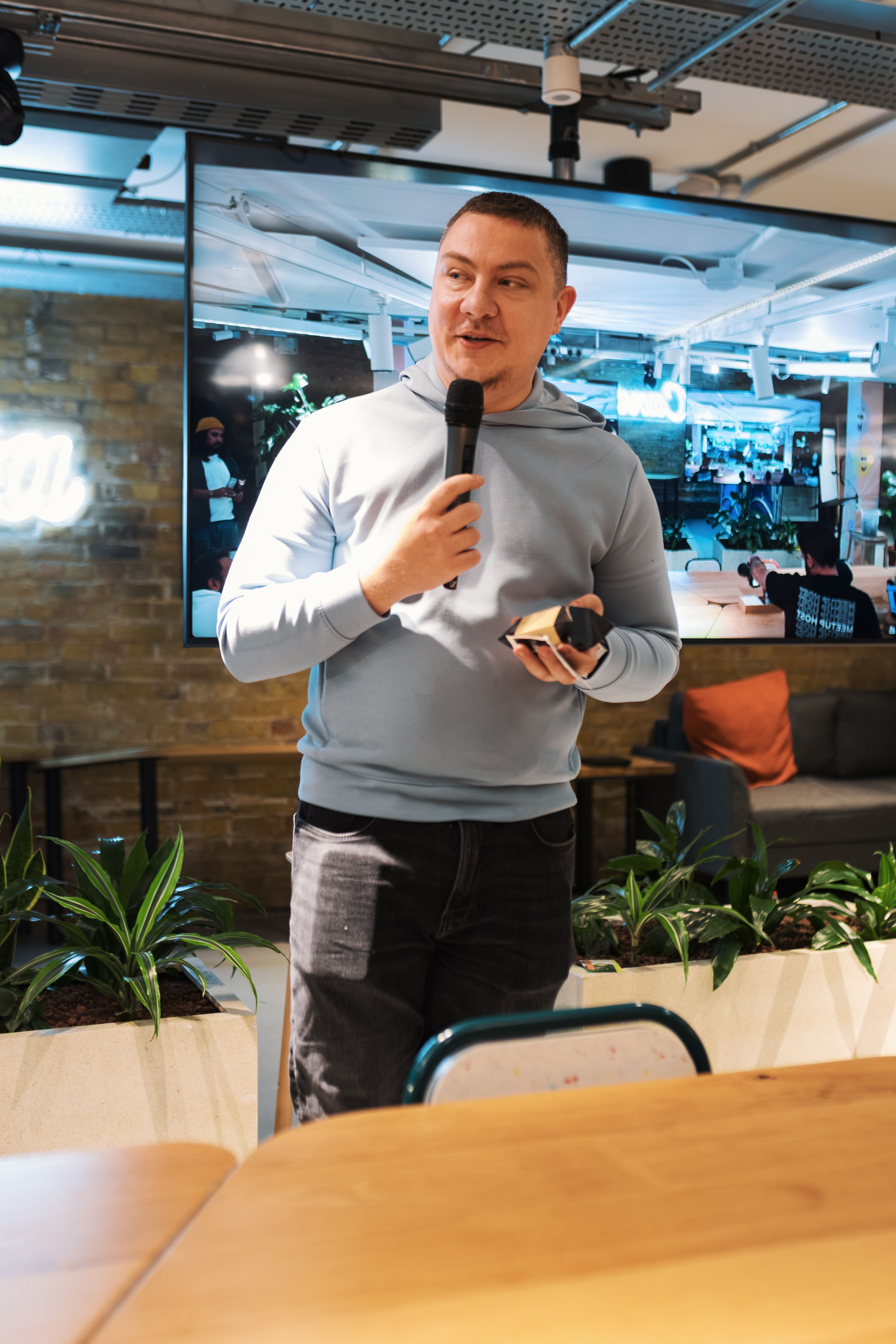 Adult male delivering a talk indoors with a microphone, engaging audience.