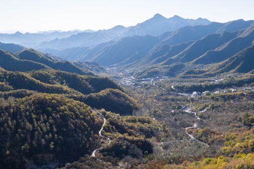 Free Stunning aerial view of a vast mountain range with lush valleys and scattered rural settlements. Stock Photo