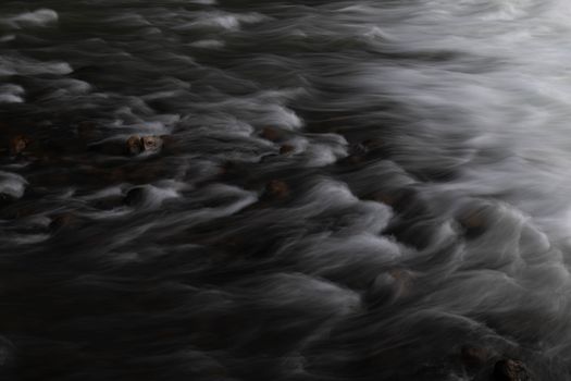 Captivating long exposure photo of water flowing over rocks, creating a soft and dreamy effect.