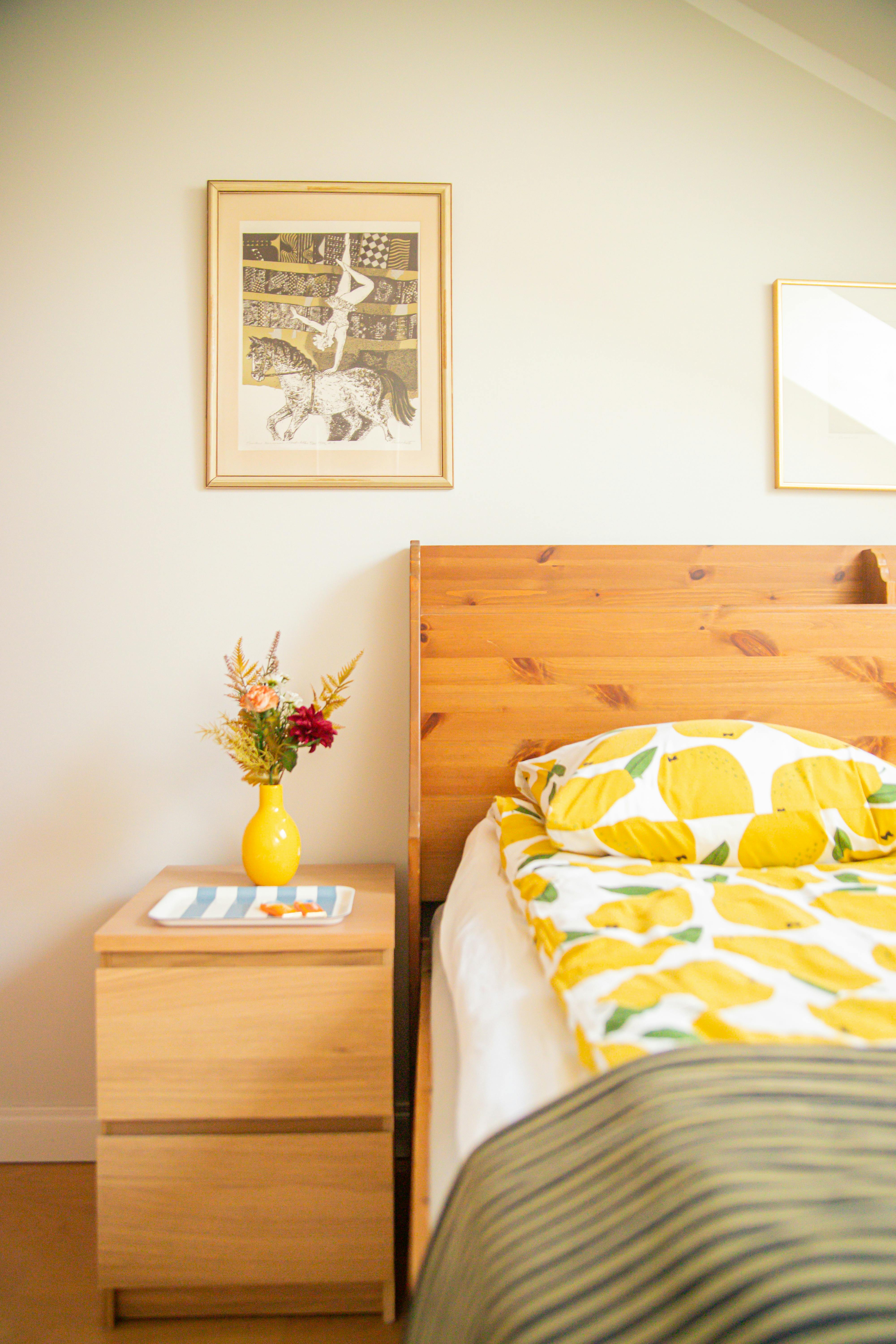 Bright bedroom with lemon print bedding and a wooden headboard.