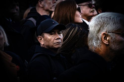Free Candid street photograph capturing diverse crowd with a focus on an intense gaze from a central figure. Stock Photo