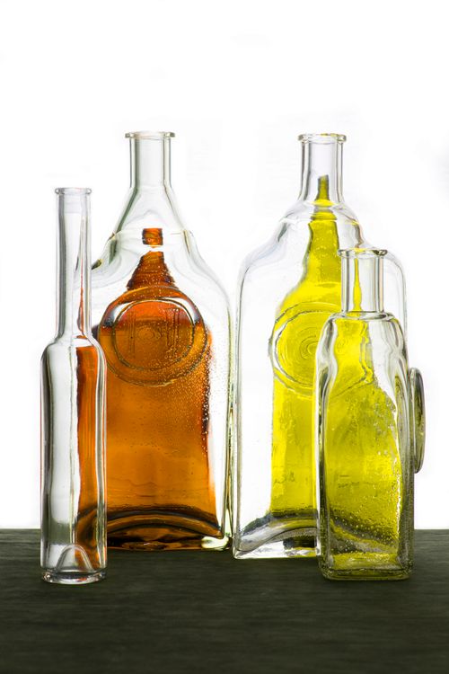 Free Still life of transparent and colorful glass bottles arranged artistically against a white background. Stock Photo