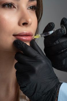 Detailed image of a cosmetic lip injection being administered by a professional.