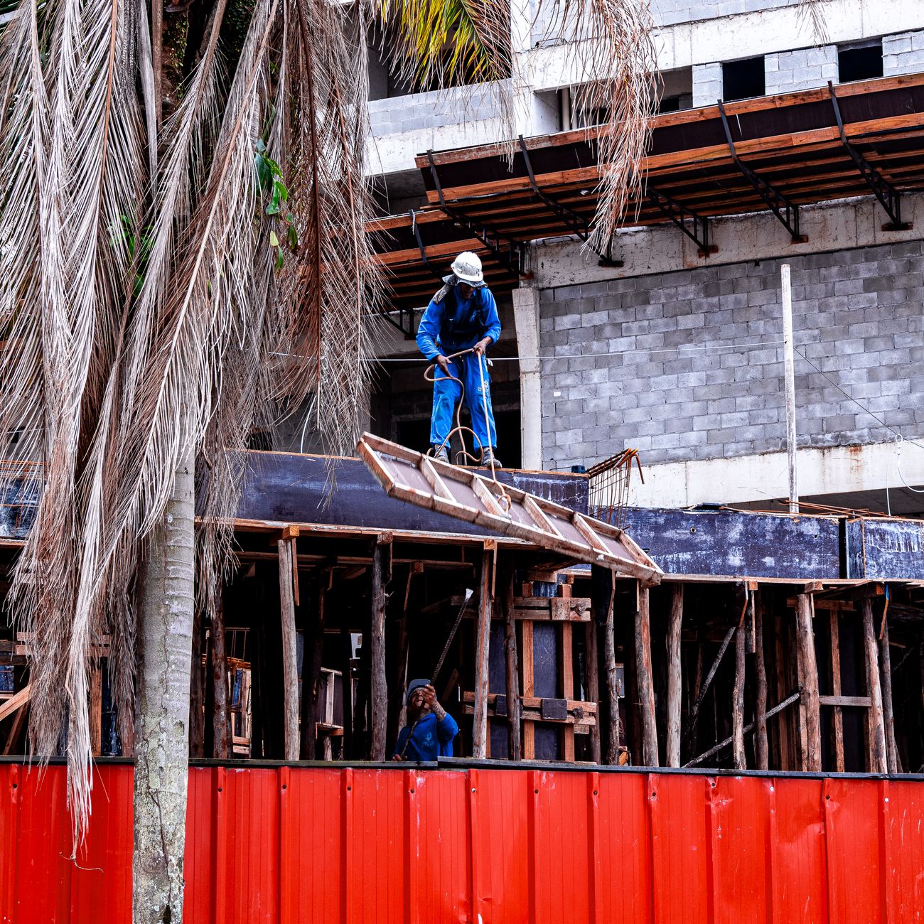 Construction workers on scaffolding at a building site in Praia Grande, São Paulo, Brazil.