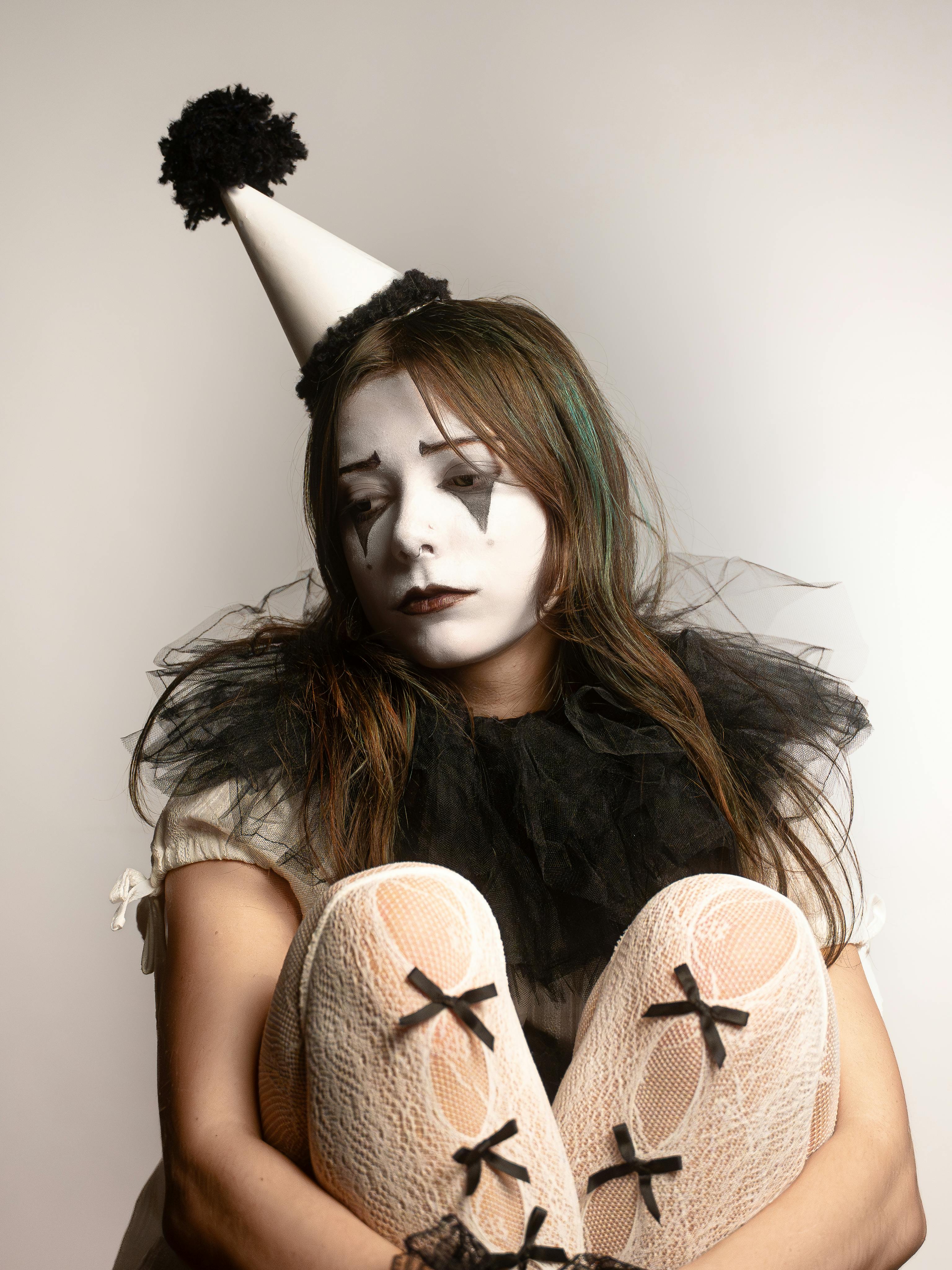 Free A thoughtful portrait of a sad clown in costume against a soft background. Stock Photo