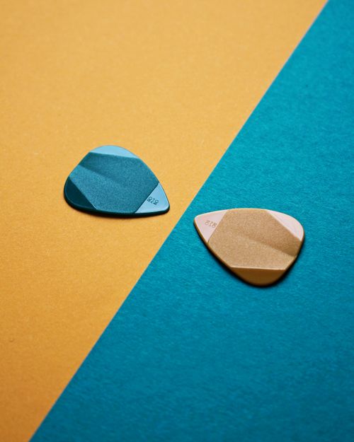 Free Bright, colorful guitar picks displayed on contrasting yellow and blue background for a modern, artistic feel. Stock Photo