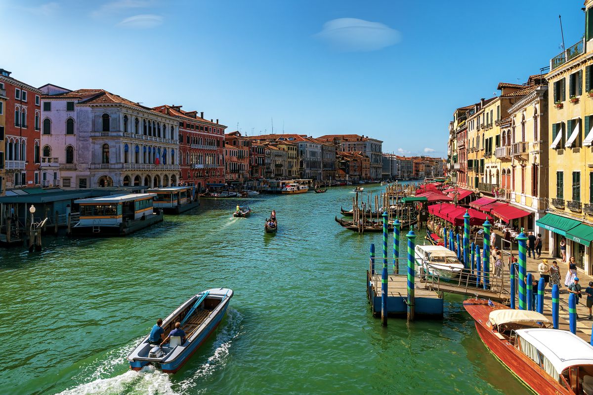 O Grande Canal em Veneza ladeado de palazzi e gondolas visto da Ponte de Rialto