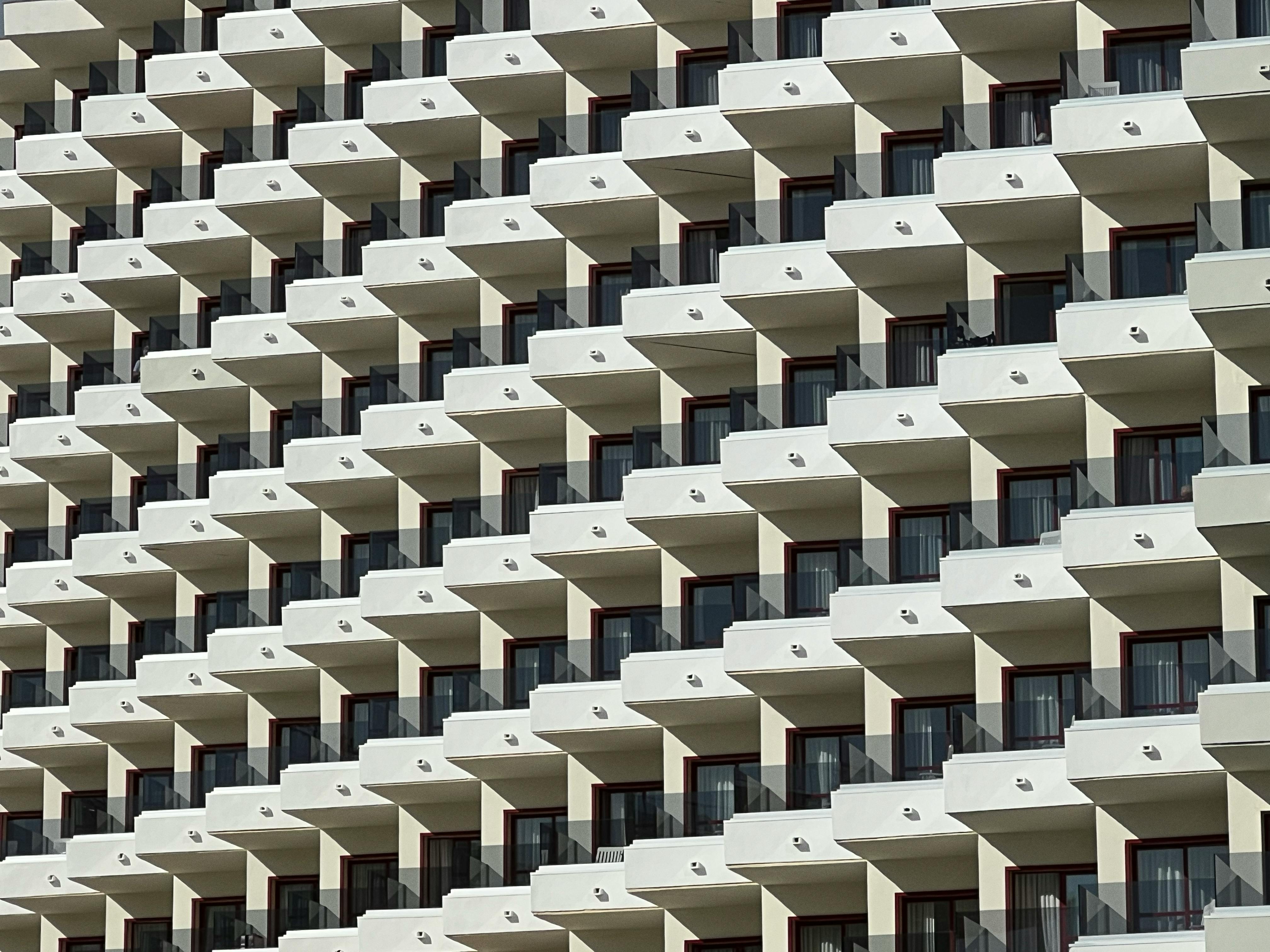 A striking display of modern hotel architecture featuring repeating balconies under clear skies.