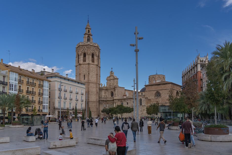 Impresionante vista de la Catedral de Valencia contra un cielo despejado en una bulliciosa plaza de la ciudad.