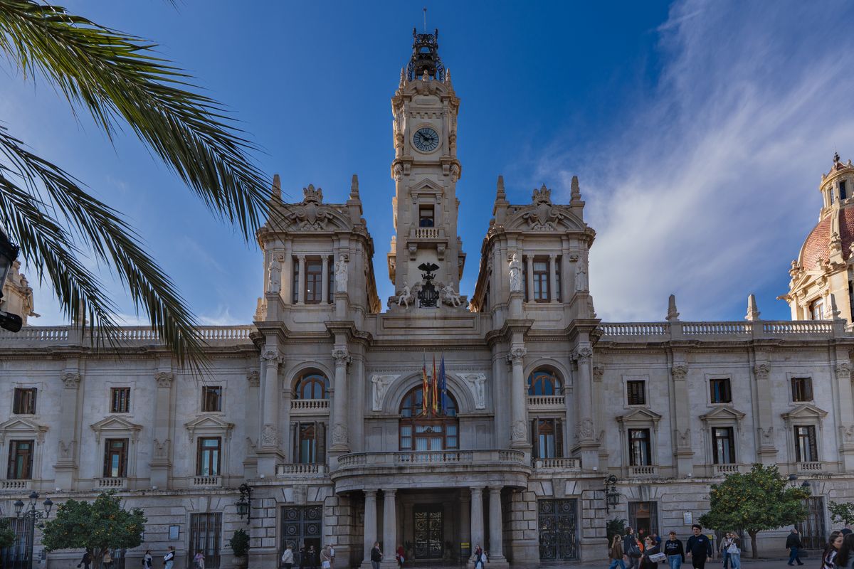 Primaria Valenciei cu turnul cu ceas si un palmier in prim-plan