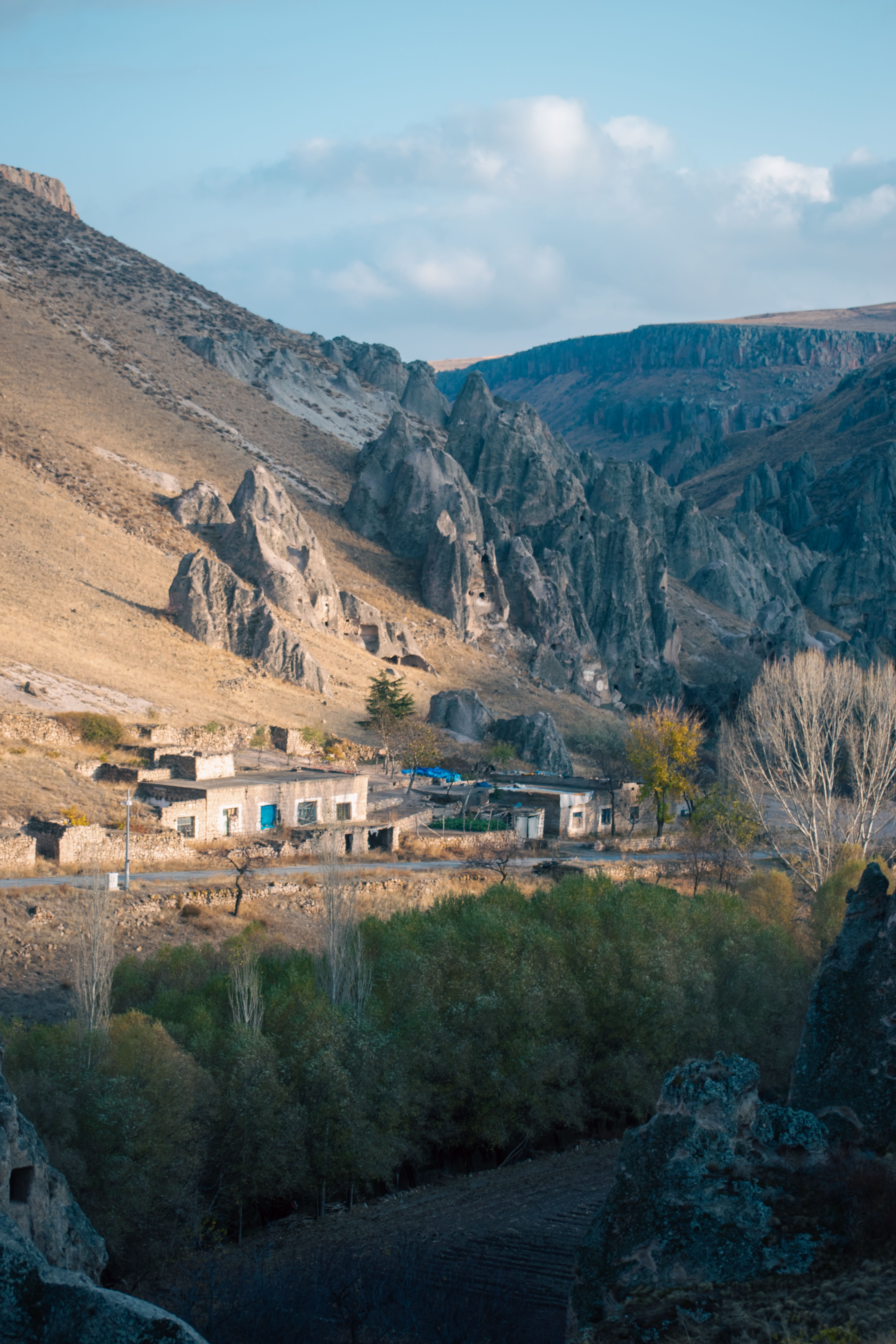 Picturesque mountain village with striking rock formations and lush greenery.