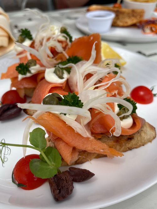 Free Delicious smoked salmon bruschetta with fresh vegetables and herbs, perfect for a gourmet meal. Stock Photo