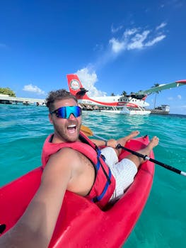 Exciting selfie while kayaking near a seaplane in crystal clear Maldives waters.