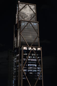 Tall illuminated skyscraper at night in New York City, showcasing its architectural details.
