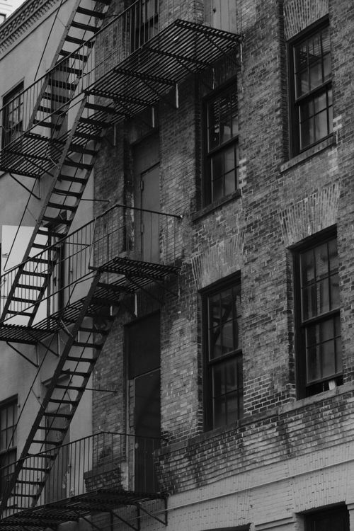 Free Black and white view of a classic fire escape on a New York City brick building. Stock Photo