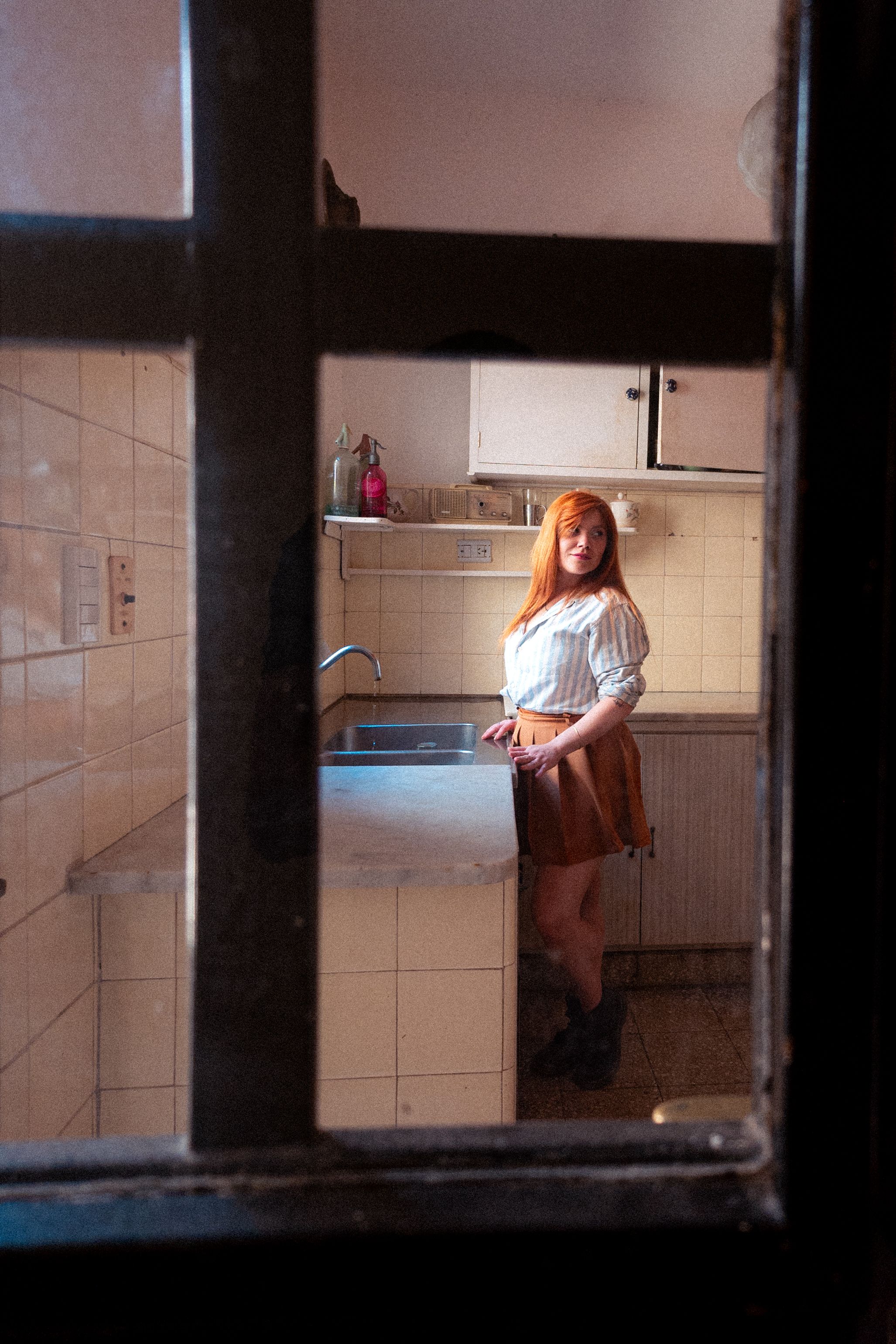 A woman stands in a vintage-style kitchen, creating a warm and nostalgic atmosphere.