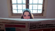 Woman Reading Newspaper by a Sunny Window