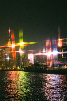 Dazzling night view of Hong Kong's skyline with colorful light streaks reflected on water.