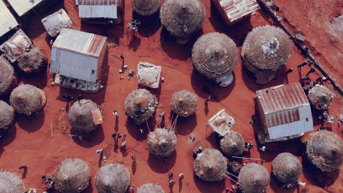 Free An overhead shot of traditional round huts and modern structures with red earth, capturing cultural architecture in Abuja, Nigeria. Stock Photo