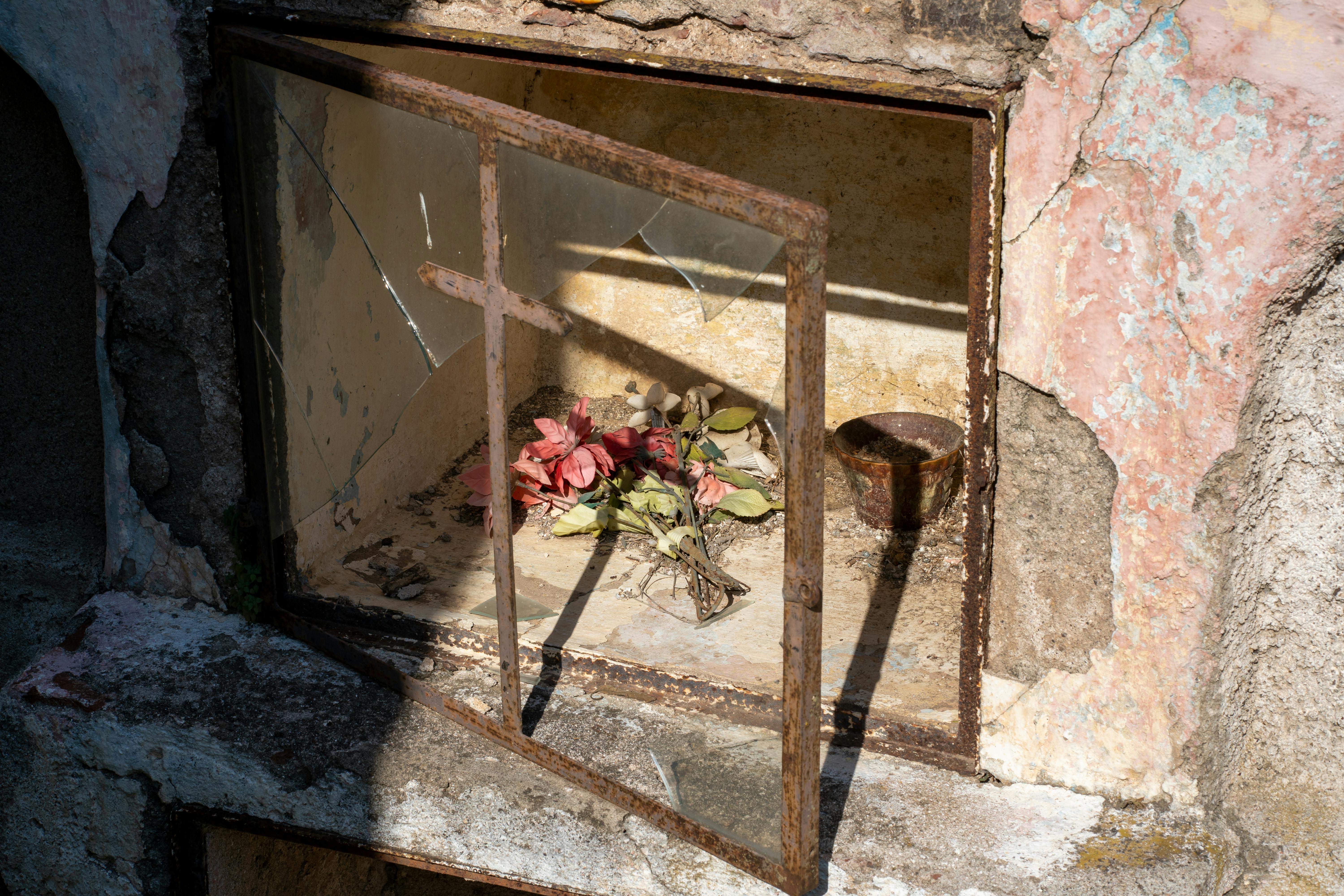 Ücretsiz Arjantin'in Punta del Agua kentinde çiçeklerle süslenmiş ve dini bir ikona sahip eski bir mezar nişi. Stok Fotoğraflar