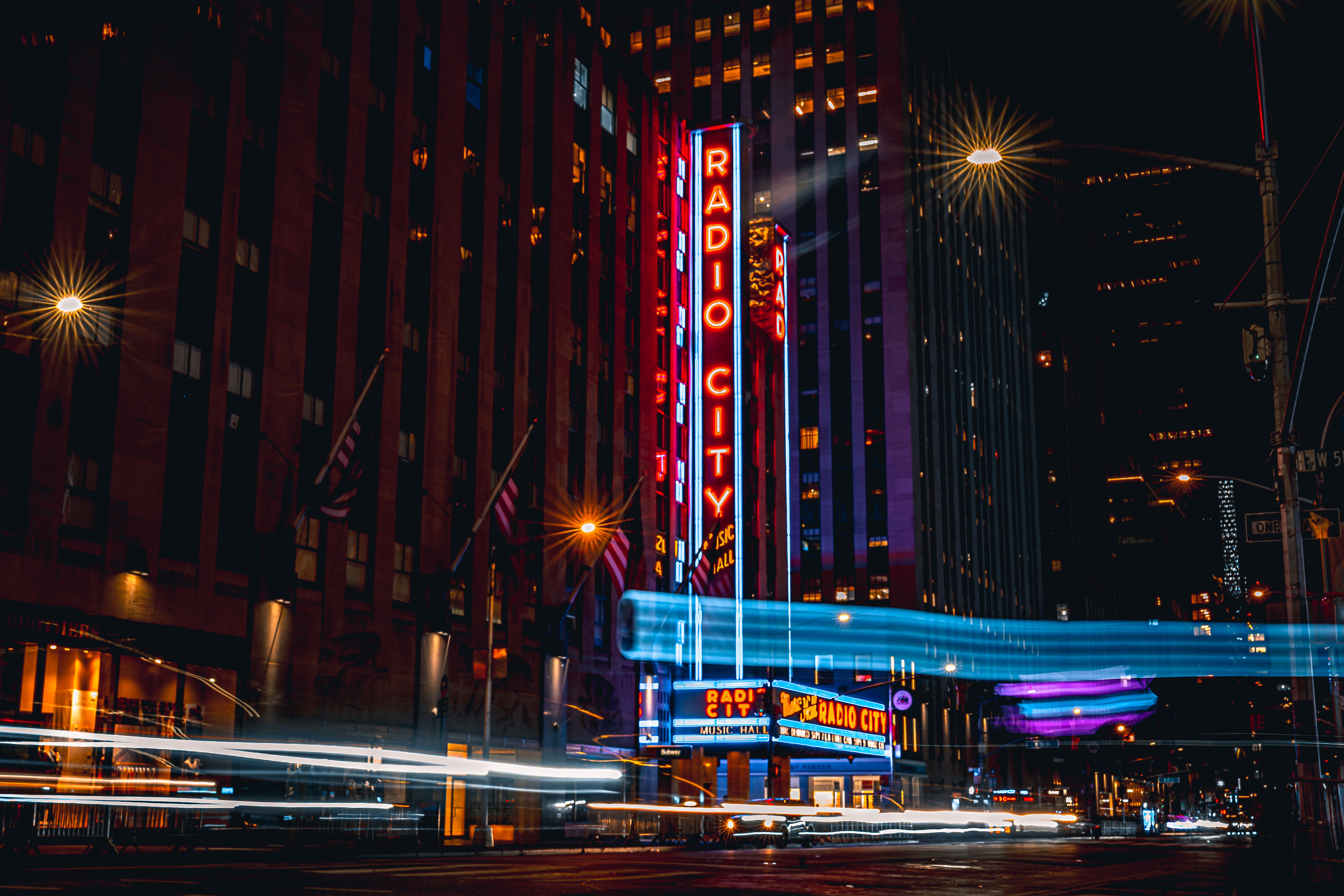 Gratis Pemandangan malam yang cerah di Radio City Music Hall dengan jejak cahaya di New York City. Foto Stok