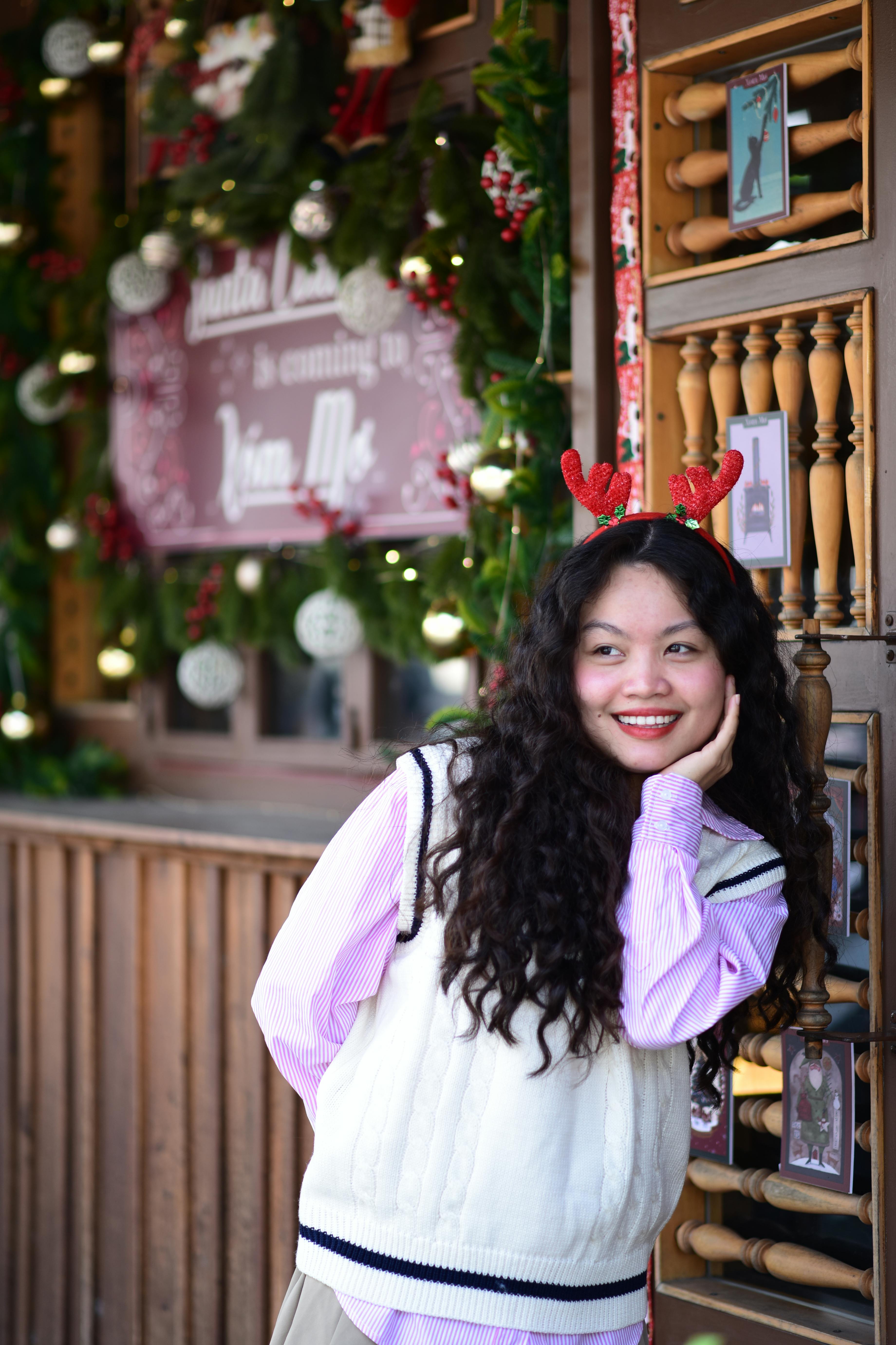 De franc Dona somrient en un ambient festiu amb banyes de ren en decoració nadalenca. Foto d'estoc