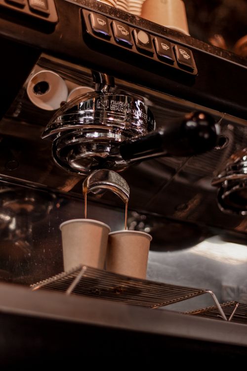 Free Close-up of aromatic espresso in paper cups being prepared with a professional coffee machine indoors. Stock Photo