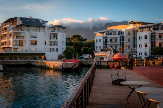 Elegant waterfront apartments in Cape Town with Table Mountain backdrop at sunset.