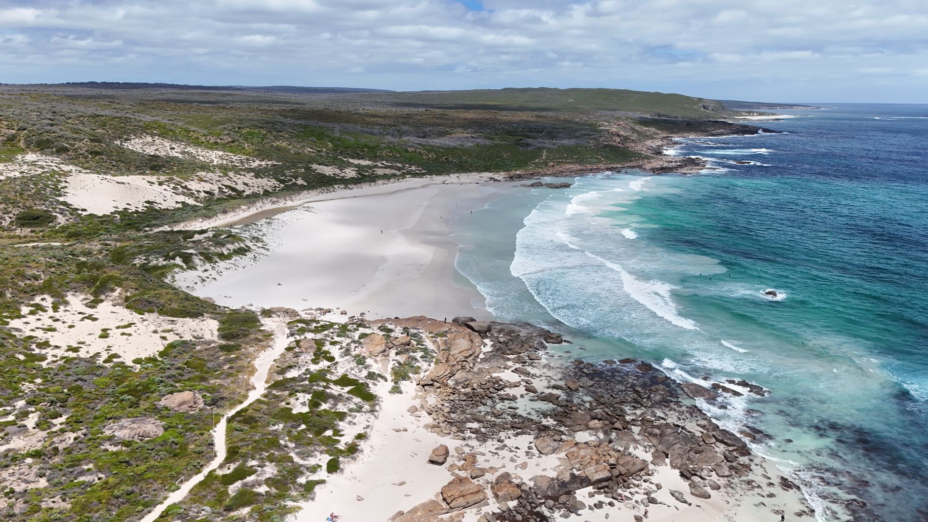 Discover the pristine beauty of a Western Australian beach with clear waters and rocky coastline.