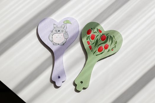 Pair of heart-shaped hand fans featuring cute illustrations, perfect for decor or gifts.