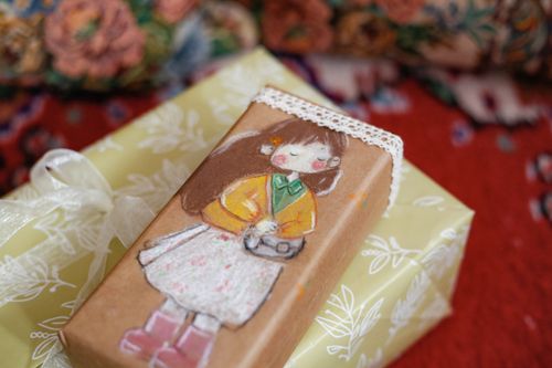 Free A beautifully wrapped gift box featuring a hand-painted illustration of a young girl with a camera. Stock Photo