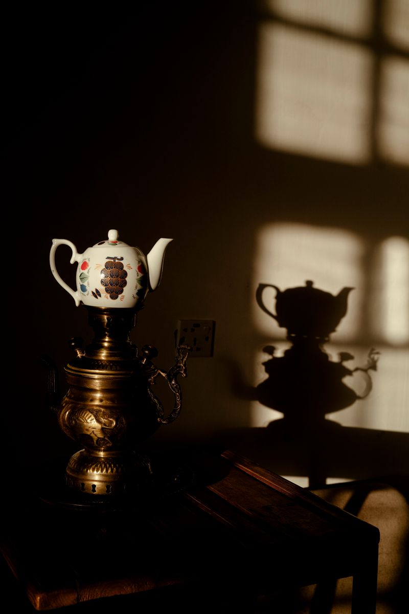 A vintage teapot casting a soft shadow, warm and storybook-like