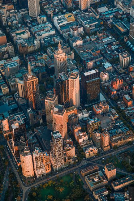 Stunning aerial shot of Melbourne with iconic skyscrapers and vibrant city layout at sunset.