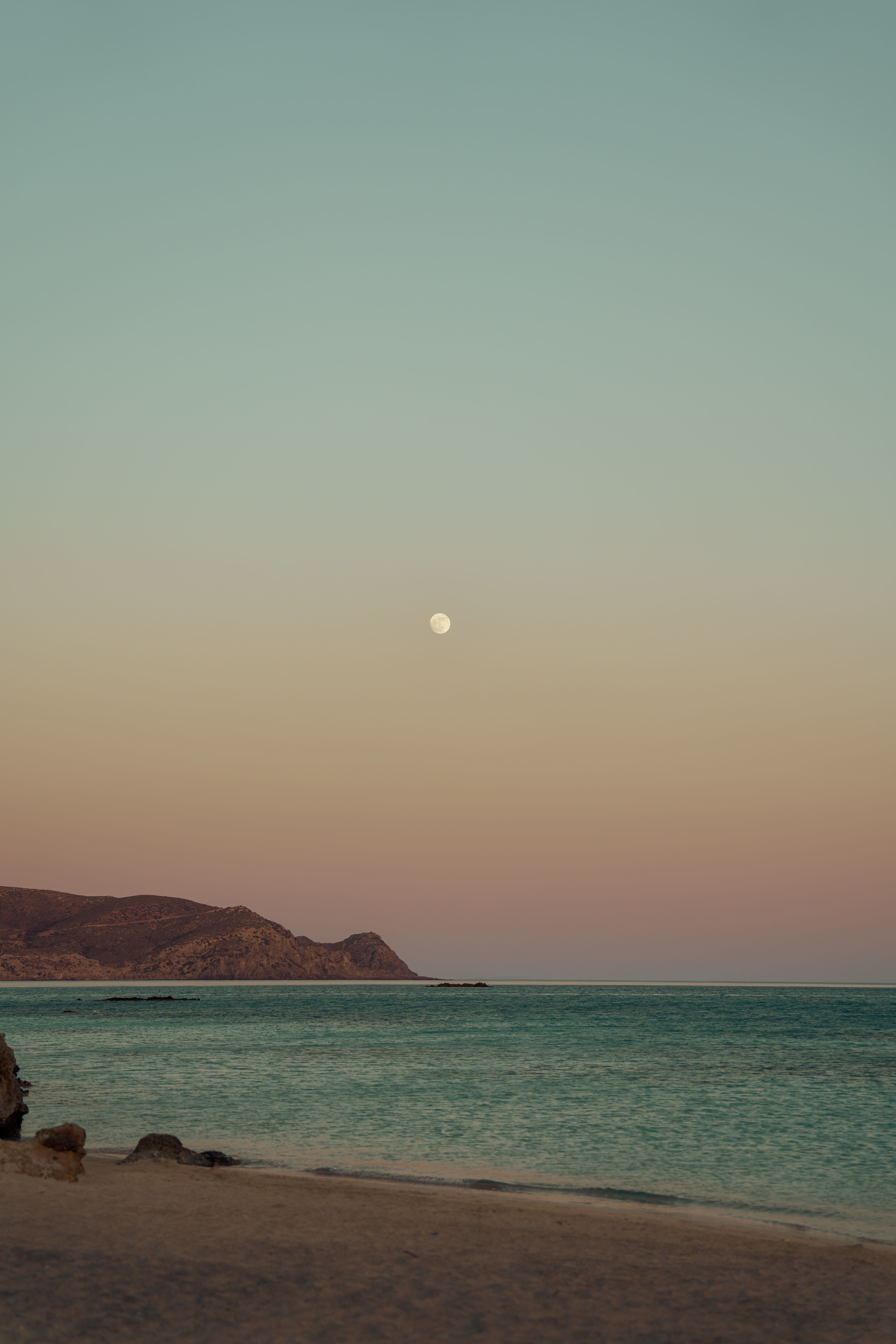 Serene Beach at Twilight with Moon Overhead · Free Stock Photo