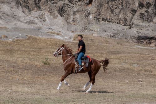 Free Man riding a horse through rocky terrain in Afyonkarahisar, Türkiye. Stock Photo