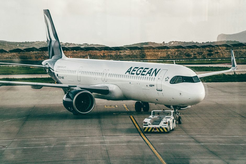 Aegean Airlines aircraft being towed at an airport, ready for takeoff.