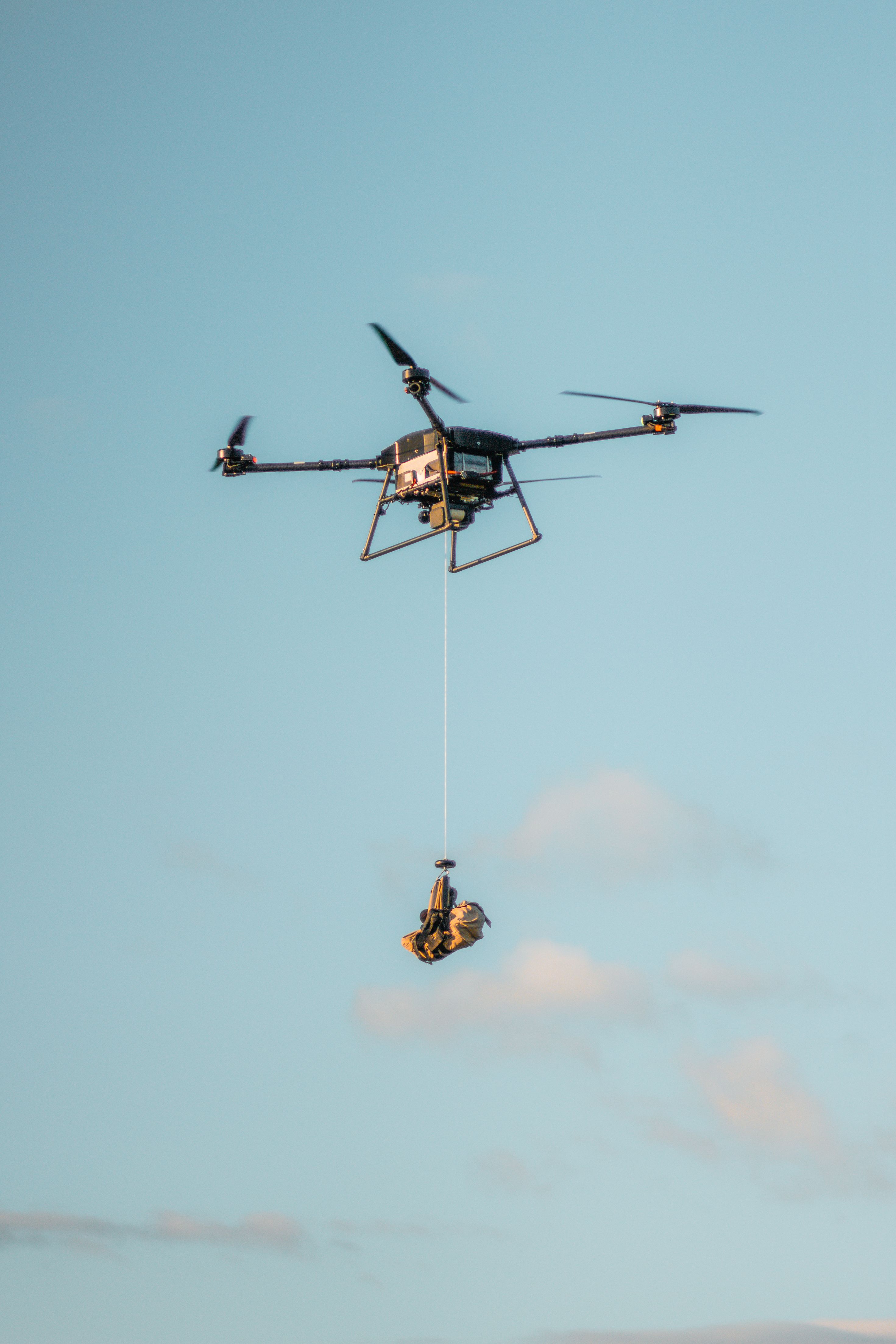 High-Tech Drone Lifting Cargo in Sky · Free Stock Photo