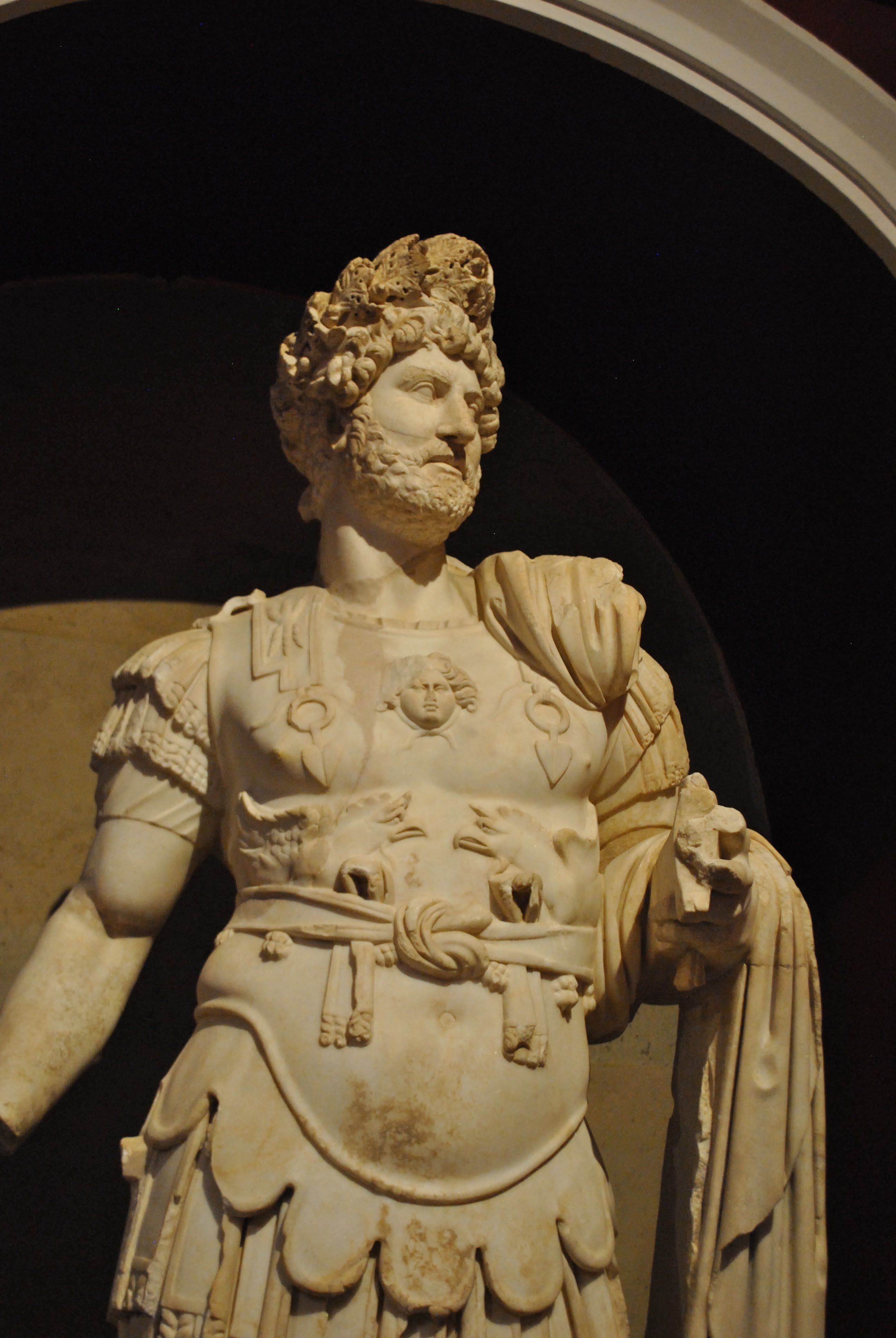 Detailed marble statue of an ancient Roman emperor displayed indoors.