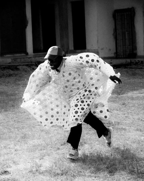 Free Black and white photo of a man dancing energetically in a flowing polka dot cloak. Stock Photo