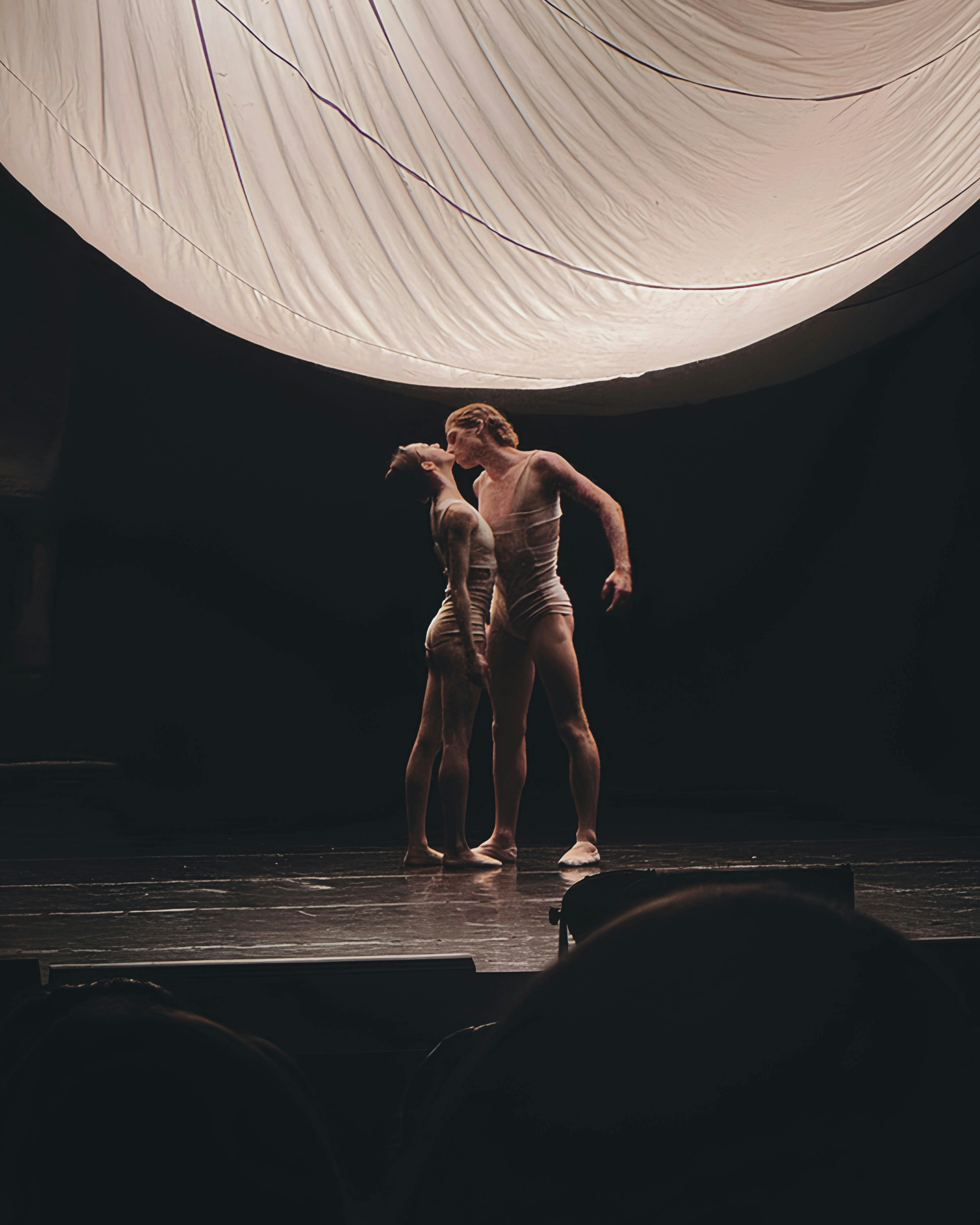 Free Two ballet dancers perform gracefully under dramatic lighting on stage. Stock Photo