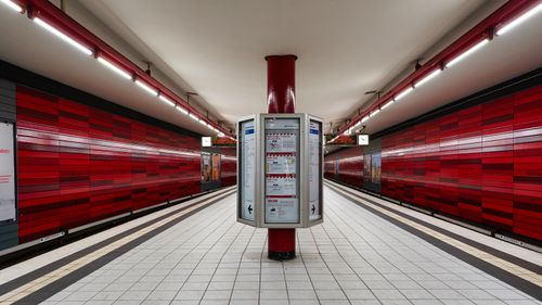 Free A modern and vibrant subway platform in Hamburg featuring red paneling and illuminated signs. Stock Photo
