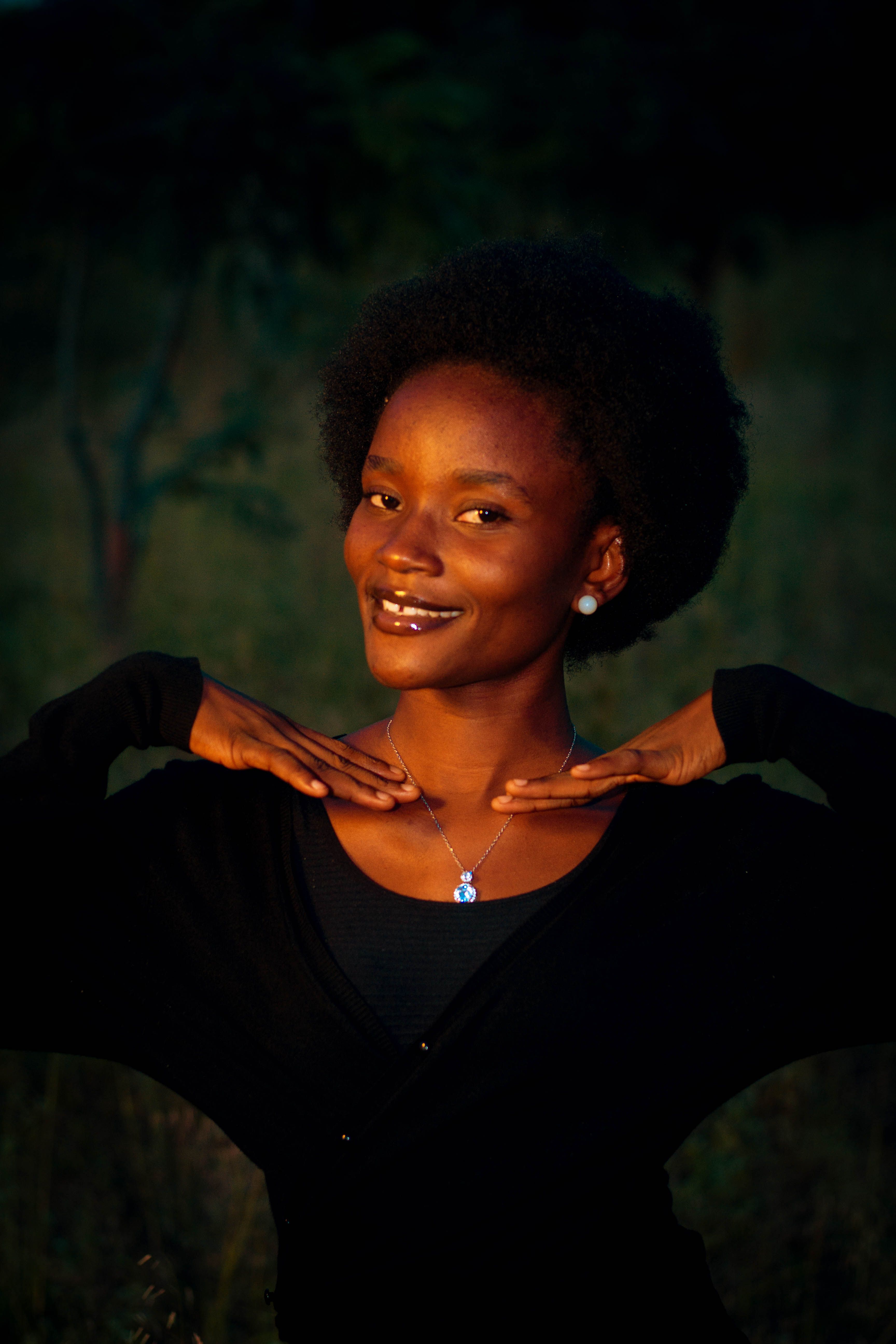 Smiling Woman Posing Outdoors in Sunset Light · Free Stock Photo
