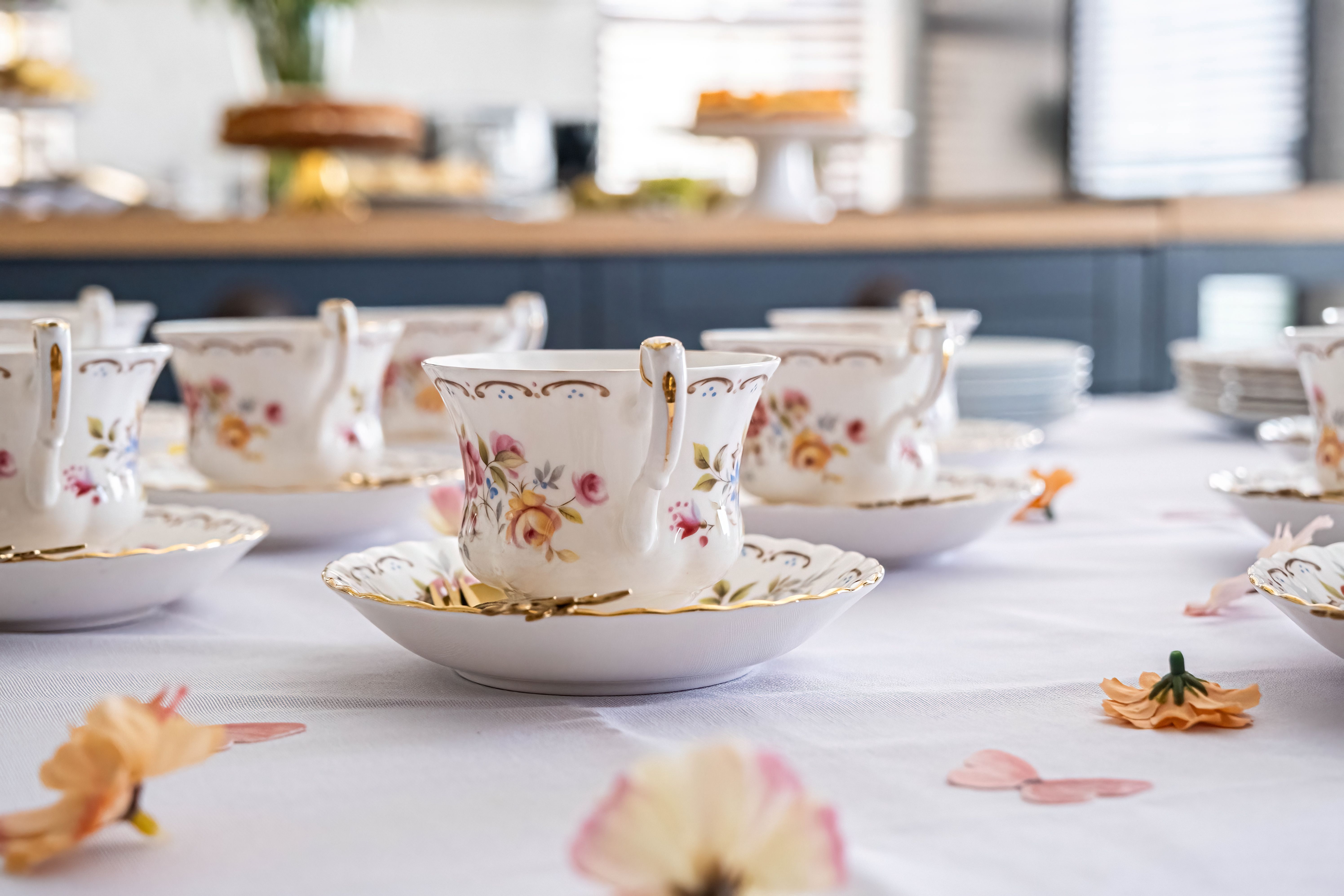 Charming floral teacups set for a refined afternoon tea party indoors.