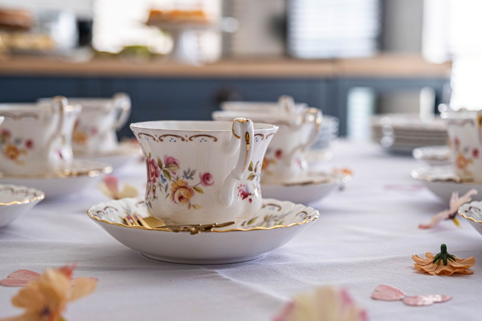 Ornate floral teacups set for a charming afternoon tea indoors.