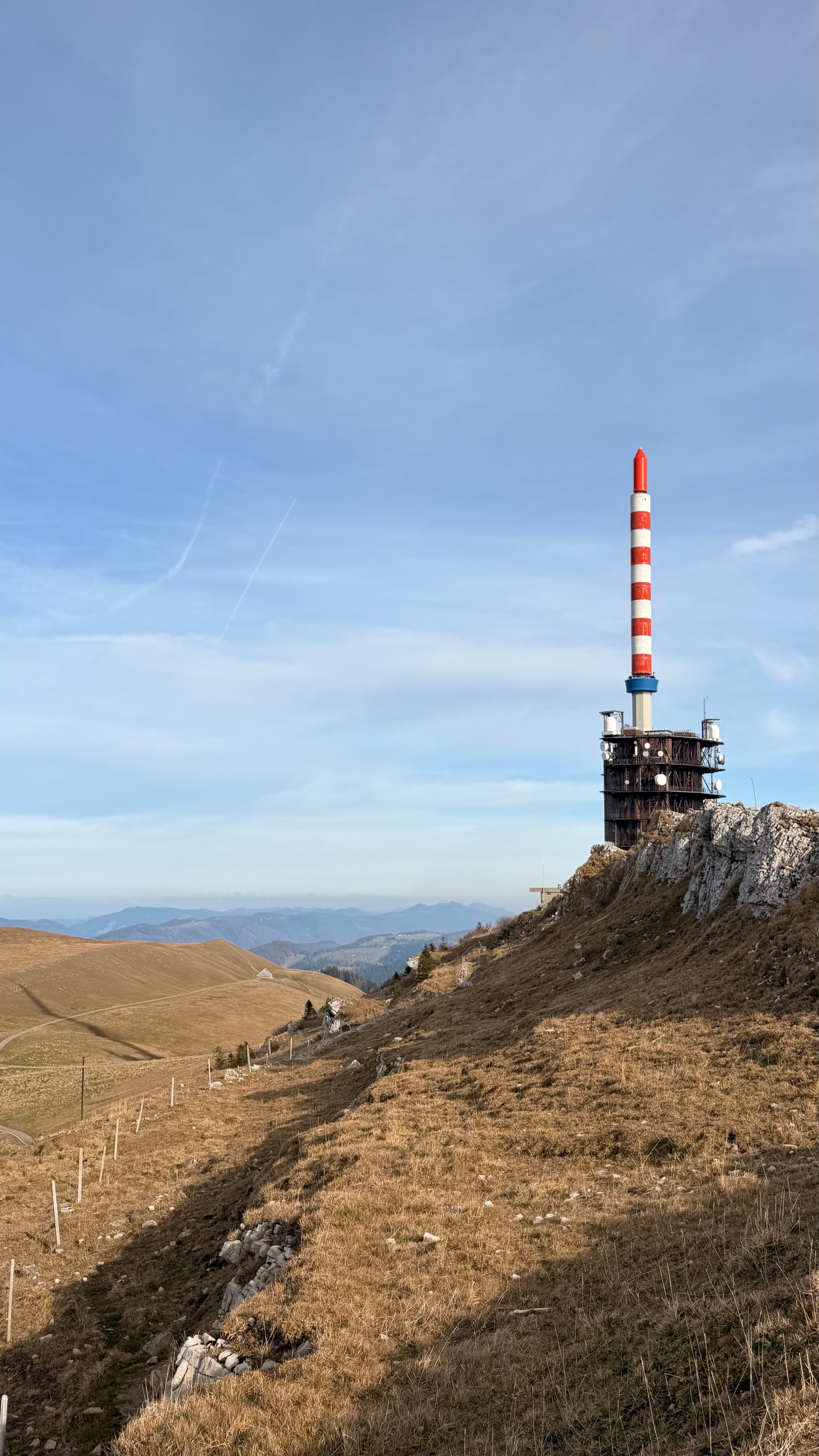 Chasseral Tower atop Jura Mountains in Switzerland, under clear blue sky.
