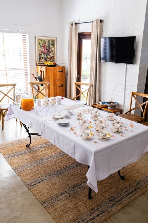 Free Bright indoor tea party setup with china set, fresh juice, and cozy atmosphere. Stock Photo