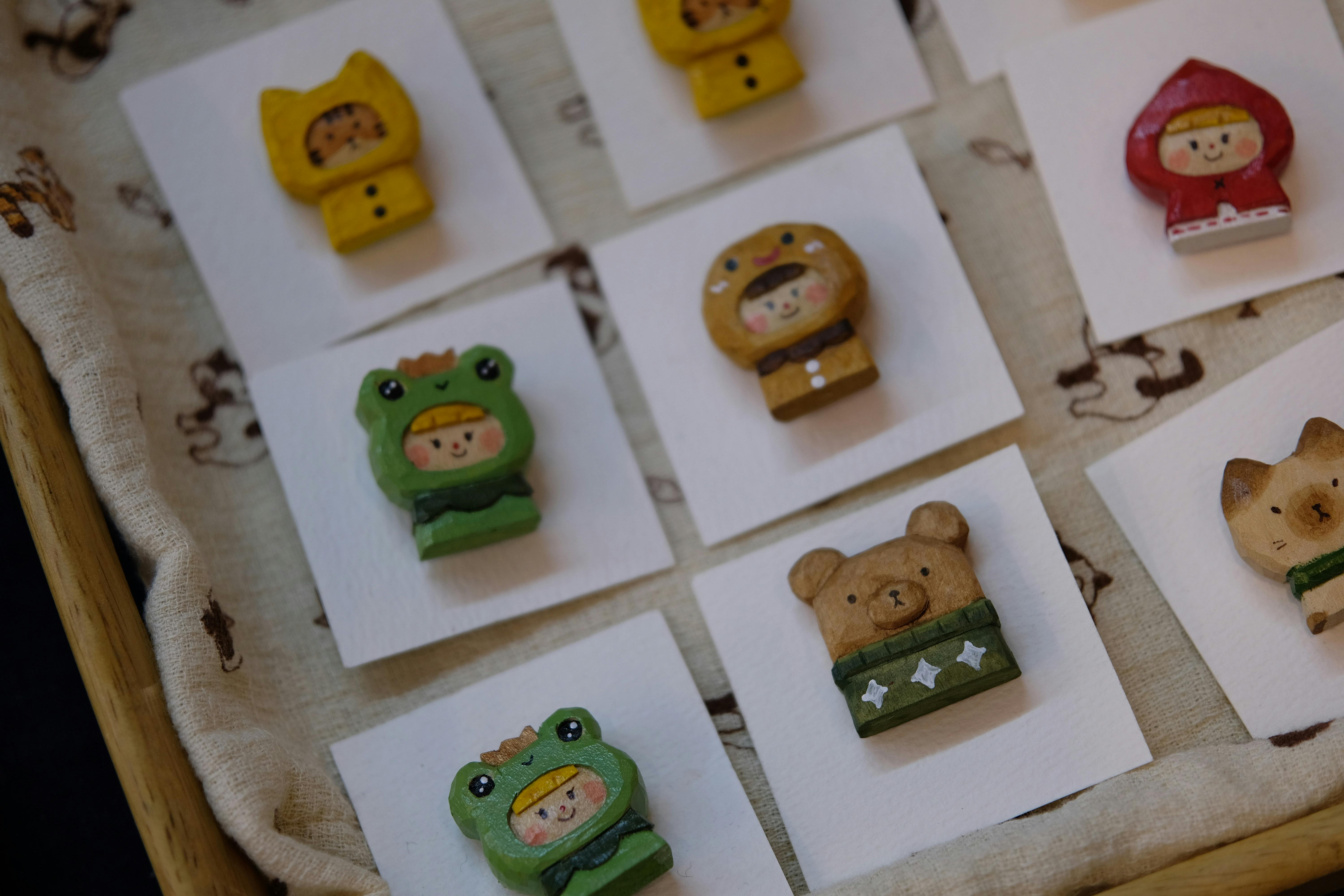 Handmade brooches depicting various cute characters on display cards.