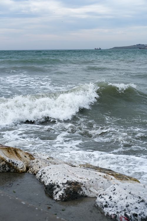 Free Waves crashing on the rocky shore of Büyükçekmece Beach, İstanbul, during an overcast day. Stock Photo