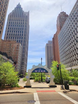 A sunny view of Detroit's skyline featuring iconic skyscrapers and a clock archway.