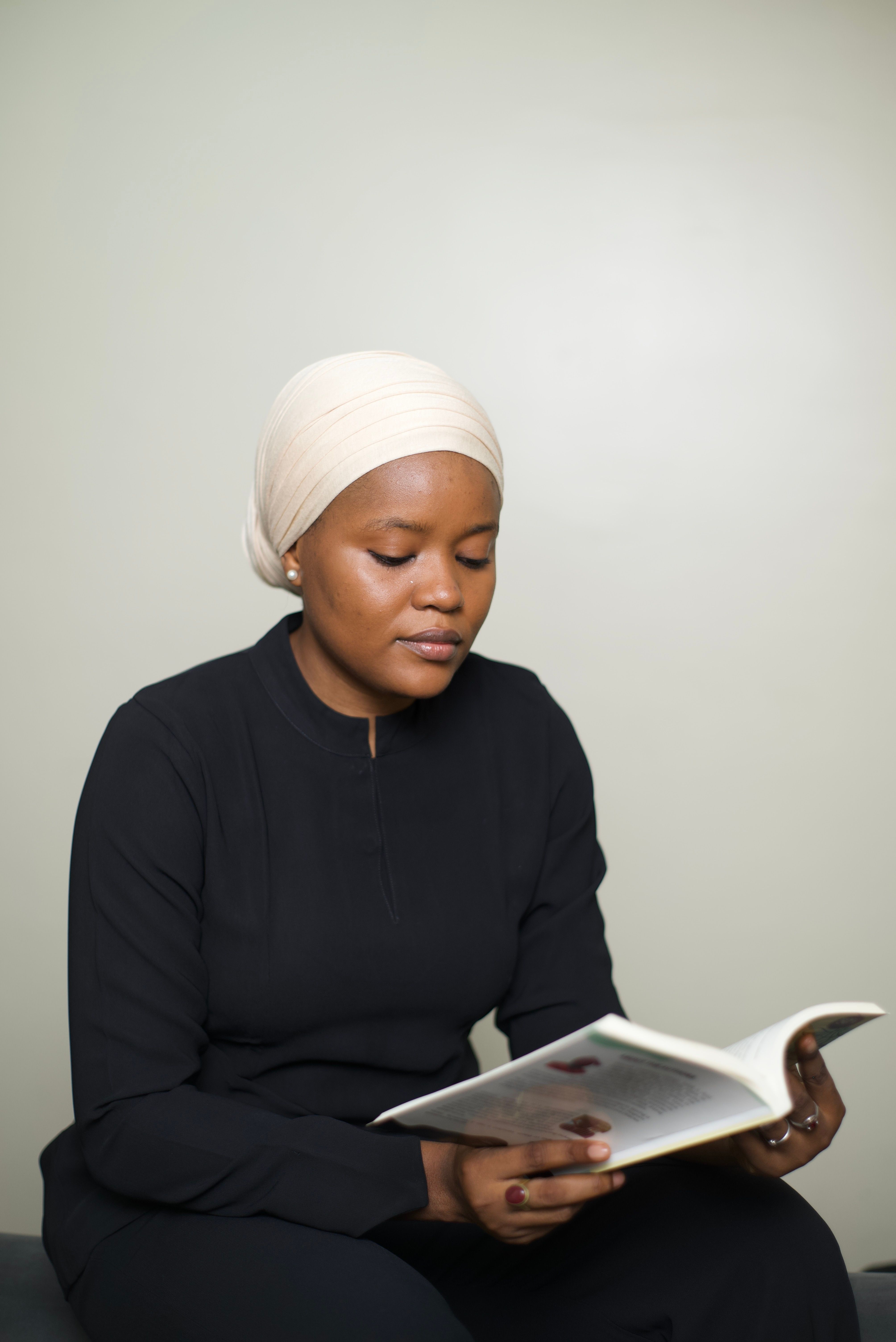 Portrait of a Thoughtful Woman Reading in Studio · Free Stock Photo